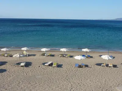 a group of chairs and umbrellas on a beach at Villa Lia Panorama in Pefki Rhodes