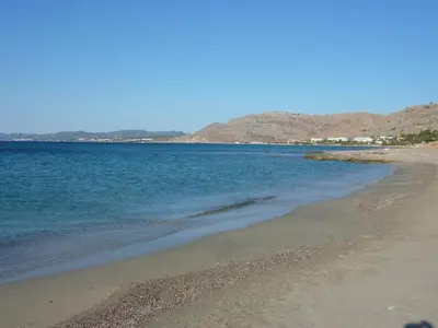 a beach with the ocean and mountains in the background at Villa Lia Panorama in Pefki Rhodes