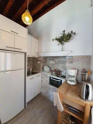 a kitchen with white cabinets and a white refrigerator at Aegean View Villas in Halki