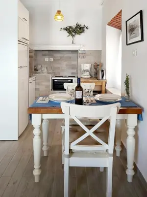 a kitchen with a table with a bottle of wine at Aegean View Villas in Halki