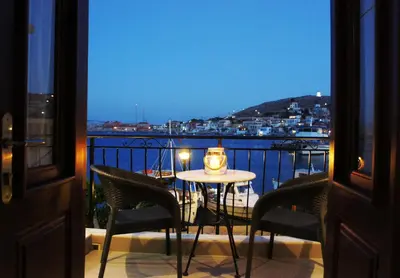 a table and chairs on a balcony with a candle at Aegean View Villas in Halki