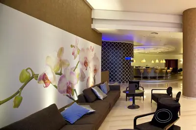 a living room with a couch and flowers on the wall at Olympic Palace Hotel in Ixia