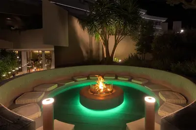 a fire pit with lights in a courtyard at night at Olympic Palace Hotel in Ixia