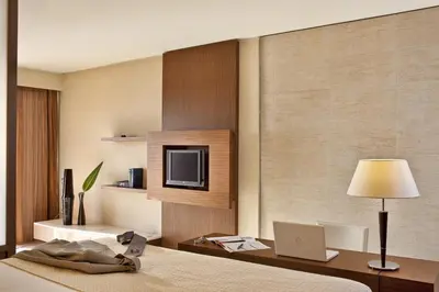 a bedroom with a bed with a laptop and a tv at Olympic Palace Hotel in Ixia