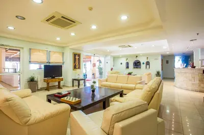 a large living room with couches and a tv at Mon Repos Hotel in Faliraki