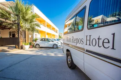 a white bus parked in front of a hotel at Mon Repos Hotel in Faliraki