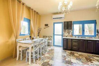a kitchen with a table and chairs in a room at Lindos Luxury Retro Villas in Líndos