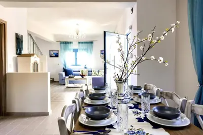 a dining room with a table with plates and chairs at Lindos Luxury Retro Villas in Líndos
