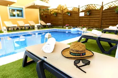 a hat sitting on a table next to a swimming pool at Lindos Luxury Retro Villas in Líndos