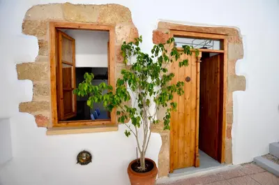 a plant in a pot next to a window at Lindos Esel Suites in Líndos
