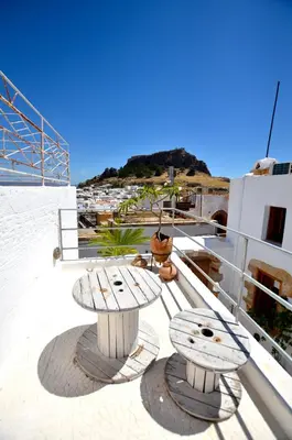 a table and bench on the deck of a boat at Lindos Esel Suites in Líndos