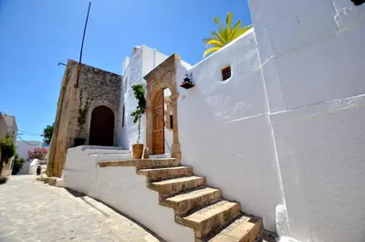 a white building with stairs on the side of it at Lindos Esel Suites in Líndos