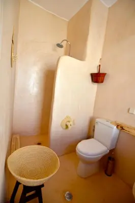 a small bathroom with a toilet and a stool at Lindos Esel Suites in Líndos