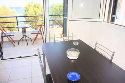 a dining room with a table and a balcony at Rodos Beach in Archangelos