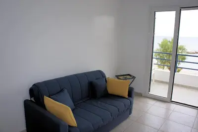 a blue couch with two yellow chairs in a living room at Rodos Beach in Archangelos