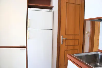 a white refrigerator in a kitchen next to a door at Rodos Beach in Archangelos