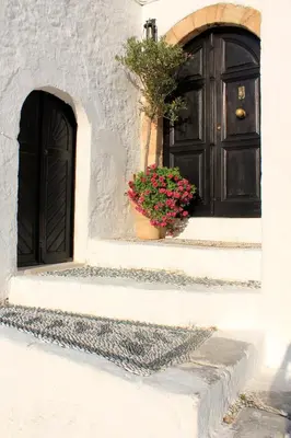 a black door and a potted plant on the steps at Rodos Beach in Archangelos