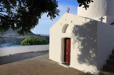 a small church with a cross on the side of it at Rodos Beach in Archangelos