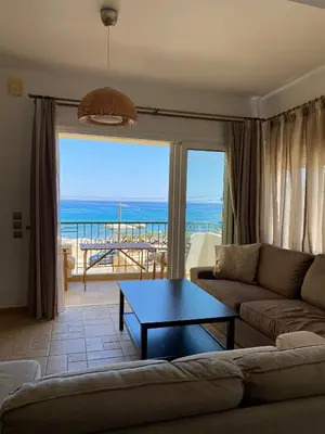 a living room with a couch and a table at Kaya Sea Studios - Stegna Beach in Archangelos