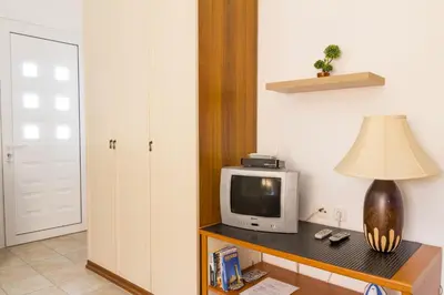 a room with a tv and a lamp on a table at Kaya Sea Studios - Stegna Beach in Archangelos