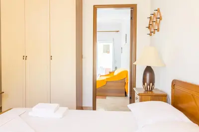 a bedroom with a white bed and a mirror at Kaya Sea Studios - Stegna Beach in Archangelos