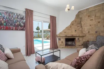 a living room with a couch and a fireplace at Mythos Luxury Villa in Faliraki