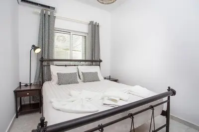 a bedroom with a bed with white sheets and pillows at Mythos Luxury Villa in Faliraki