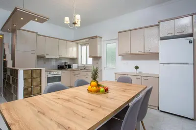 a kitchen with a wooden table with a bowl of fruit on it at Mythos Luxury Villa in Faliraki