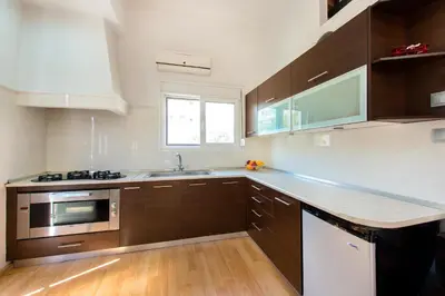 a kitchen with brown cabinets and a sink and a window at Amazing apartment 300 meters from the Old Town in Rhodes Town