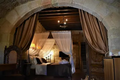 a bedroom with two beds and an arch with curtains at S.Nikolis' Historic Boutique Hotel in Rhodes Town