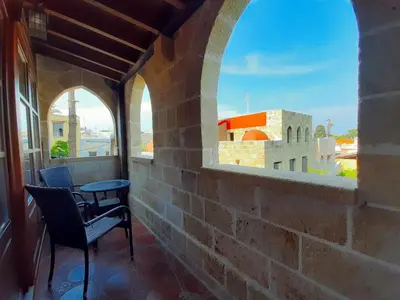 a balcony with a table and chairs and a view at S.Nikolis' Historic Boutique Hotel in Rhodes Town