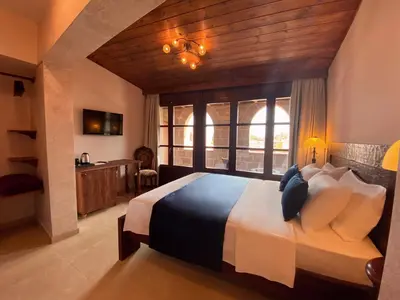 a bedroom with a large bed and a desk and window at S.Nikolis' Historic Boutique Hotel in Rhodes Town