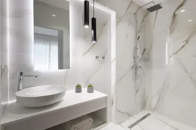 a white bathroom with a sink and a shower at Harmony Elegant Central Apartment in Rhodes Town
