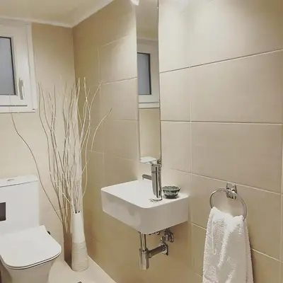 a white bathroom with a sink and a toilet at Harmony Elegant Central Apartment in Rhodes Town