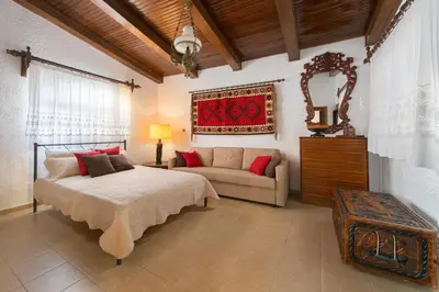 a bedroom with a bed and a couch at Villa Agia Paraskevi in Ialyssos