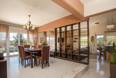 a dining room with a table and chairs at Athina's Villa with heated pool in Koskinou
