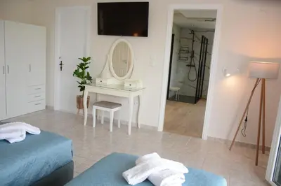a bedroom with a bed and a table with a mirror at Athina's Villa with heated pool in Koskinou