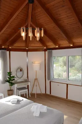 a bedroom with a bed and a chandelier at Athina's Villa with heated pool in Koskinou