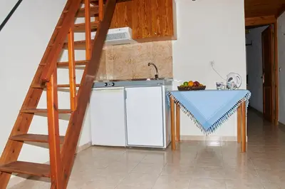 a kitchen with a ladder next to a white refrigerator at Kamares Studios in Symi