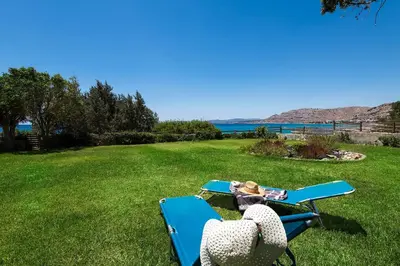 a picnic table and two chairs in the grass at Villa Sole Mare in Pefki Rhodes