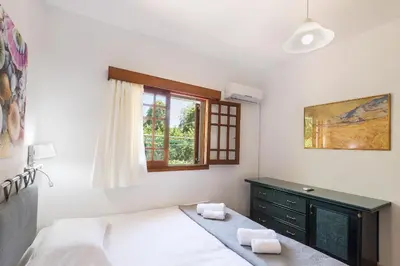 a bedroom with a bed and a dresser and a window at Villa Sole Mare in Pefki Rhodes