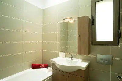 a bathroom with a sink and a mirror and a tub at Blue Dream Exclusive villas privees in Pefki Rhodes