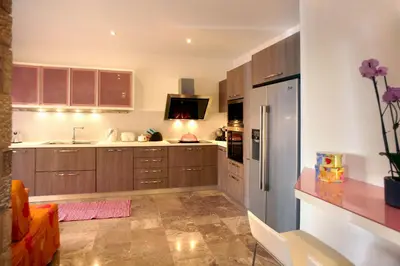 a kitchen with wooden cabinets and a refrigerator at Blue Dream Exclusive villas privees in Pefki Rhodes
