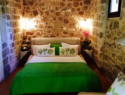 a bedroom with a bed with green sheets and pillows at George & Alexandra's Apartments in Rhodes Town