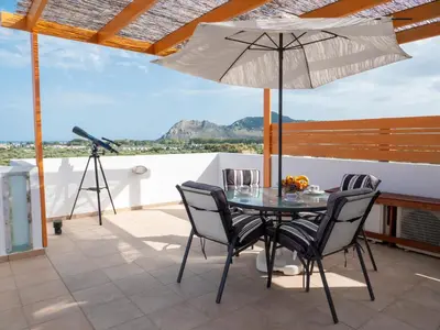a table with chairs and an umbrella on a patio at Villa Elia in Kolimbia