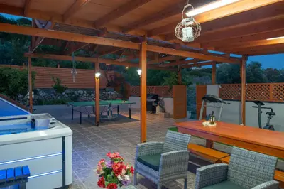 a patio with a table and chairs and a table and a grill at Villa Elia in Kolimbia