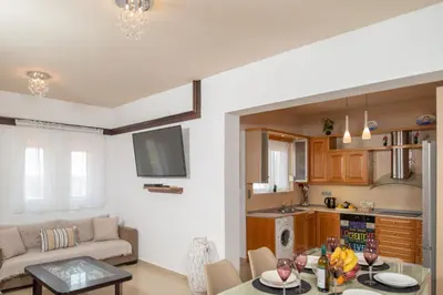 a kitchen and living room with a table and a couch at Villa Elia in Kolimbia