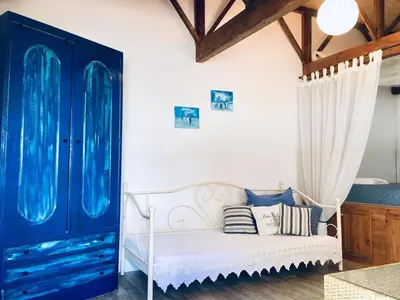 a bedroom with a white bed and a blue cabinet at Sandra Studio in Lachania