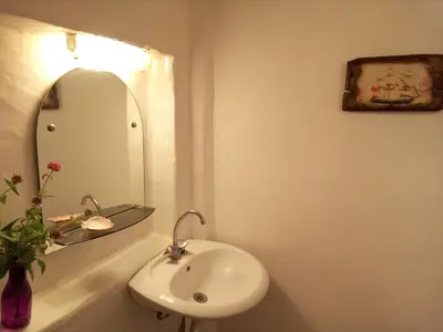 a white bathroom with a sink and a mirror at Sandra Studio in Lachania