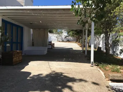 a garage with a blue door and a tree at Sandra Studio in Lachania